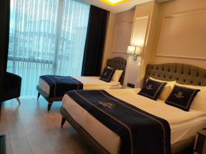 ArnavutköyにあるLoft Airport Hotel'sのベッド2台と窓が備わるホテルルームです。