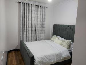 Emani Luxury Condo tesisinde bir odada yatak veya yataklar