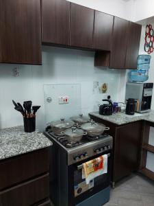 una cucina con 2 pentole e padelle su un piano cottura di Emani Luxury Condo a Nakuru