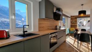 a kitchen with a sink and a view of a mountain at Mattertal Lodge in Embd