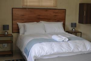 a bedroom with a bed with two towels on it at Kosi Khaya in Manguzi