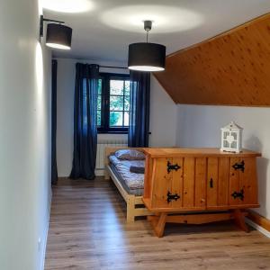 sypialnia z łóżkiem i drewnianą komodą w obiekcie Willa Jaszczurówka w Zakopanem