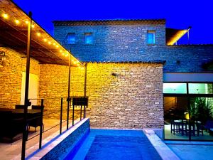 un bâtiment en briques avec des lumières sur son côté dans l'établissement Les Pres de Gordes, à Gordes