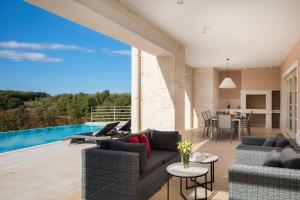 patio z kanapą, krzesłami i stołem w obiekcie Villa Blanche by ILC (Istria Luxury Collection) w mieście Brtonigla