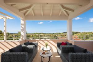 a screened in porch with two couches and a table at Villa Blanche by ILC (Istria Luxury Collection) in Brtonigla