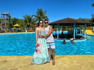 a man and a woman standing in front of a pool at Tijota Hotel Fazenda in Ipatinga
