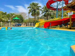 a child in a pool with a water slide at Tijota Hotel Fazenda in Ipatinga