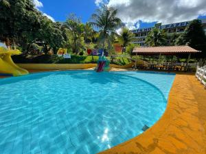 a swimming pool with a slide in a resort at Tijota Hotel Fazenda in Ipatinga