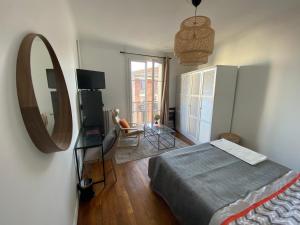 a bedroom with a bed and a mirror on the wall at Grande chambre privative à 20 minutes de Paris in Colombes