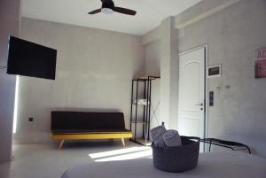 ein Wohnzimmer mit einem Sofa und einem Deckenventilator in der Unterkunft Staying in Athens in Athen