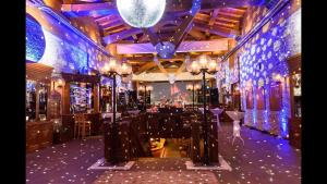 een kamer met een bar met blauwe verlichting op de muren bij Pirin Golf Hotel Private Studios in Razlog