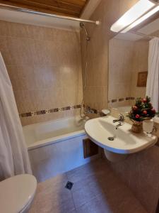 een badkamer met een wastafel, een toilet en een bad bij Pirin Golf Hotel Private Studios in Razlog