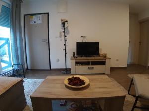 a living room with a television and a table with a bowl on it at Ajrin Apartman Kopaonik in Kopaonik