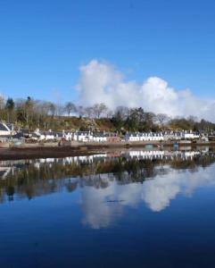 a large body of water with houses in the background at Duirinish Pods with Private Hot Tubs and Duirinish Bothy with No Hot Tub in Plockton