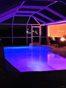 einen Pool mit lila Beleuchtung in einem Haus in der Unterkunft Villa Tortuga - Place to Relax in Cape Coral