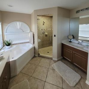 een badkamer met een bad, een wastafel en een douche bij Villa Tortuga - Place to Relax in Cape Coral