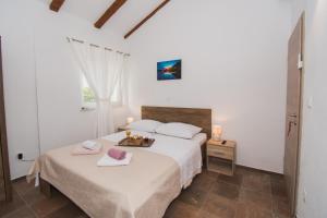 a white bedroom with two beds and a window at Marcelovi dvori in Pirovac