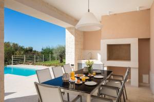 comedor con mesa, sillas y piscina en Villa Divine by ILC (Istria Luxury Collection) en Brtonigla