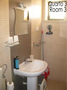a bathroom with a sink and a mirror at Alojamento Tiago & Jorge Guesthouse in Nazaré