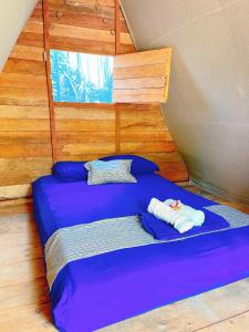 Una cama con dos toallas en una habitación en La Aldea Holbox Cabañas y Camping, en Isla Holbox
