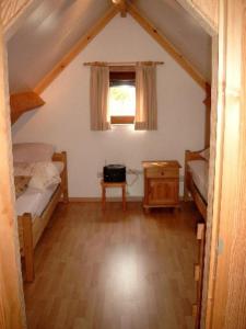 a attic room with two beds and a window at Vakantiehuisje De Haan in De Haan