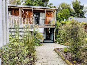 a house with a balcony and a patio at Kaka Retreat Motel, Stewart Island in Half-moon Bay