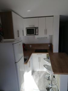 een kleine keuken met witte kasten en een aanrecht bij APPARTEMENT VALMEINIER 1800 / RESIDENCE L'OURS BLANC in Valmeinier