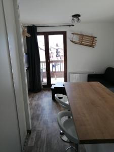 a dining room with a table and chairs and a window at APPARTEMENT VALMEINIER 1800 / RESIDENCE L'OURS BLANC in Valmeinier