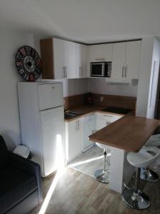 a kitchen with white cabinets and a wooden table at APPARTEMENT VALMEINIER 1800 / RESIDENCE L'OURS BLANC in Valmeinier