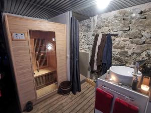 La salle de bains en pierre est pourvue d'un lavabo et d'une douche. dans l'établissement Sweet Loft Grenoble-Love Room avec jacuzzi & sauna, à Grenoble