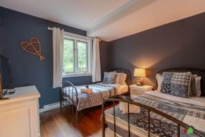 a childs bedroom with two beds and a window at Unique Tremblant view -fancy fully equipped apartment in Mont-Tremblant