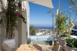 a patio with a table and chairs and a swimming pool at Edem Boutique Suites in Oia