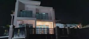 a large white building with a balcony at night at Puma Aparthotel - Nyarutarama in Kigali