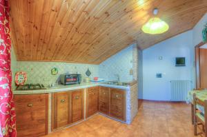 cocina con armarios de madera y techo de madera en Appartamenti De Sanctis, en Villetta Barrea