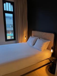 een slaapkamer met een wit bed en een raam bij Casa Clementina - 3 Bedroom Apartment in a Art-Nouveau House in Gent