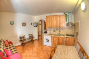 una cucina con tavolo, lavandino e forno a microonde di Appartamenti De Sanctis a Villetta Barrea