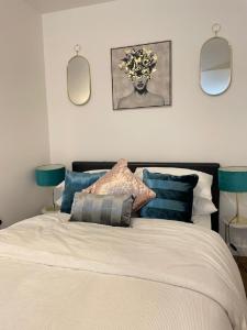 a bedroom with a bed with pillows and two mirrors at CityNights Studios with Free Parking in Liverpool