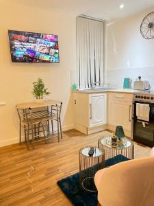 a living room with a kitchen and a table with a table at CityNights Studios with Free Parking in Liverpool