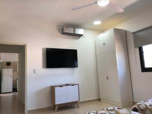 a living room with a flat screen tv on a wall at Paseo Camila in Goya