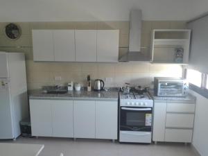 a kitchen with white cabinets and a stove top oven at Paseo Camila in Goya