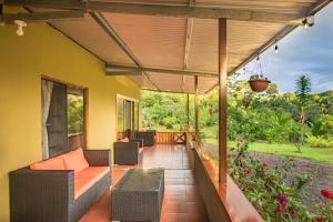 an outdoor patio with orange cushioned furniture and awning at Casa Danta in Drake