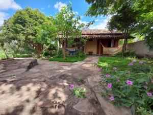 a house with a hammock in the yard at Pousada Refazenda - Milho Verde in Milho Verde