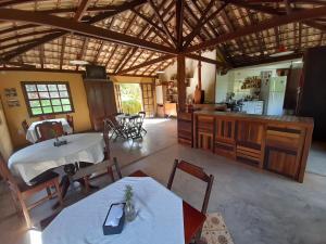 an open kitchen and dining room with tables and chairs at Pousada Refazenda - Milho Verde in Milho Verde