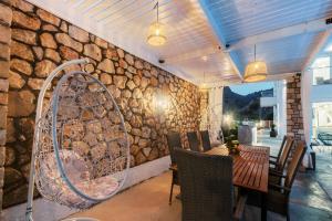 a dining room with a stone wall with a table and chairs at Lindos Villa Aqua Euphoria ex Natura in Lindos