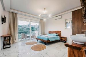 a bedroom with a bed and a sink and a tub at Lindos Villa Aqua Euphoria ex Natura in Lindos +46 photos