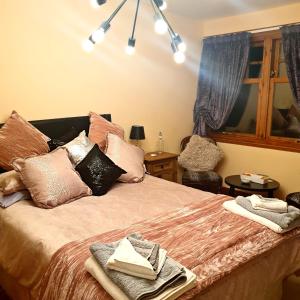 a bedroom with a bed with pillows and a window at Bogenraith House in Banchory