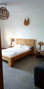 a bedroom with a wooden bed with two lamps at Appartement haut standing avec piscine in Yaoundé