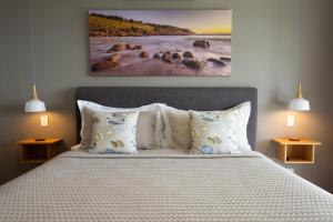 
a bed with a white comforter and pillows on it at Sea Dragon Kangaroo Island in Penneshaw
