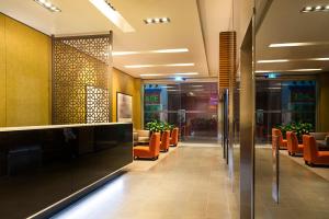un vestíbulo con sillas naranjas en un edificio en Causeway 353 Hotel, en Melbourne