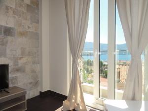 a room with a large window with white curtains at The Old Town Viewpoint Apartments in Budva
